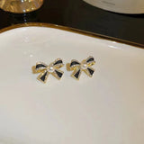 Delicate and small pearl black bow earrings
