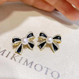 Delicate and small pearl black bow earrings